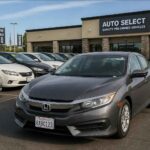 Szary Honda Civic na pierwszym planie przed salonem samochodów używanych Auto Select
